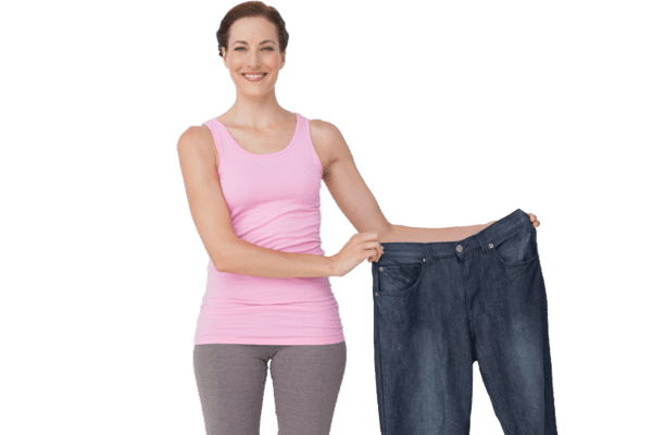 Smiling woman of hcg weight loss holding old oversized pants